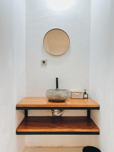 a sink on a wooden shelf with a mirror at Ginastro Hom in Bangli