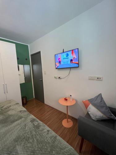 a bedroom with a bed and a tv on the wall at Casa do Zafer in São Paulo