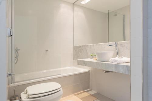 Baño blanco con aseo y lavamanos en Fliphaus Zapiola 2300 'b' - 1 Bd Belgrano en Buenos Aires