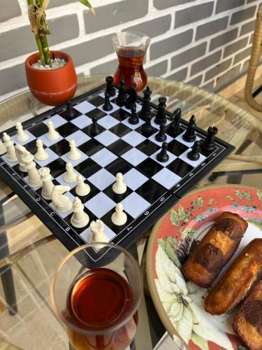 un tablero de ajedrez en una mesa junto a un plato de comida en Casa do Zafer en São Paulo