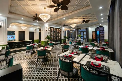a restaurant with tables and chairs and a ceiling at Elegant Boutique Hotel Ha Long in Ha Long