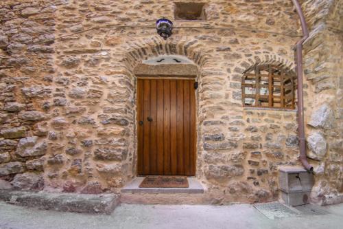 a stone building with a wooden door and a window at Byzantine Home in the Castle in Mesta