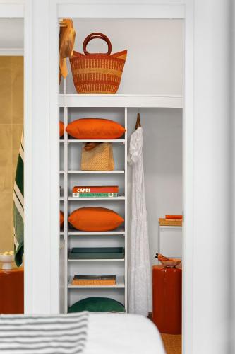 a white closet with a basket on top of it at 3 Sunshine Central - Sophisticated Apartment in Sunshine Beach