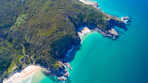 an aerial view of a tropical island with blue water at 3 Sunshine Central - Sophisticated Apartment in Sunshine Beach