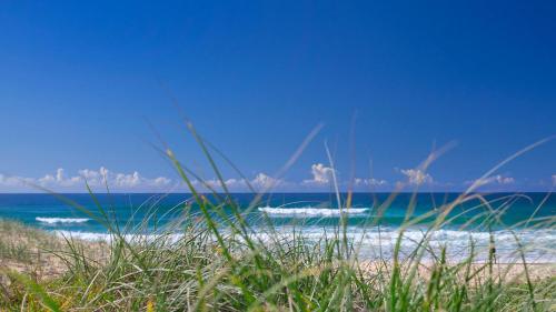 a beach with two boats in the water at 3 Sunshine Central - Sophisticated Apartment in Sunshine Beach