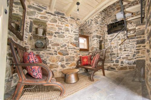 Habitación con 2 sillas y pared de piedra. en Byzantine Home in the Castle, en Mestá