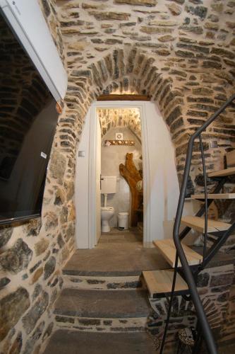 a bathroom with a stone wall and a stair way at Byzantine Home in the Castle in Mesta