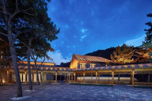 a building with a fence in front of a building at Jinshanling Great Wall Hotel in Chengde