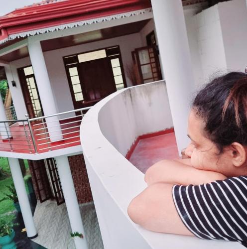 a woman sleeping on a balcony of a house at White Win Villa in Elewala