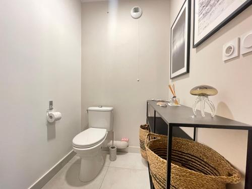 La salle de bains est pourvue de toilettes et d'une table noire. dans l'établissement Appartement de standing 3 pièces avec clim, garage double, proche plages et commerces à Sète - FR-1-338-572, à Sète