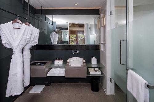 La salle de bains est pourvue d'un lavabo et d'un miroir. dans l'établissement Jinshanling Great Wall Hotel, à Chengde