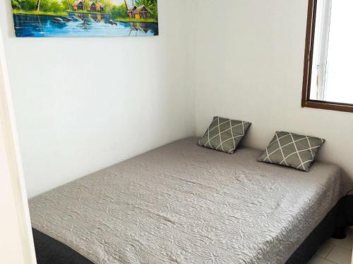 - un lit avec deux oreillers dans l'établissement Appartement T2 cabine avec piscine, parking, proche mer et commerces - Cap d'Agde - FR-1-607-196, au Cap d'Agde