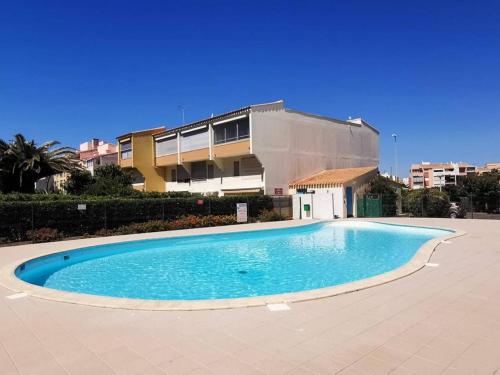 une grande piscine devant un immeuble dans l'établissement Appartement T2 cabine avec piscine, parking, proche mer et commerces - Cap d'Agde - FR-1-607-196, au Cap d'Agde