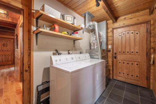 a laundry room with a washer and dryer at Cozy Pet-Friendly Cabin w Private Hot Tub Fenced In Yard Walk to HOA Beach & Pier in Homewood