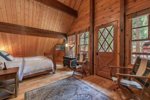 a bedroom in a log cabin with a bed and a desk at Cozy Pet-Friendly Cabin w Private Hot Tub Fenced In Yard Walk to HOA Beach & Pier in Homewood