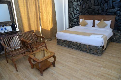 a hotel room with a bed and a chair at Kallisto Resort Skardu in Skardu