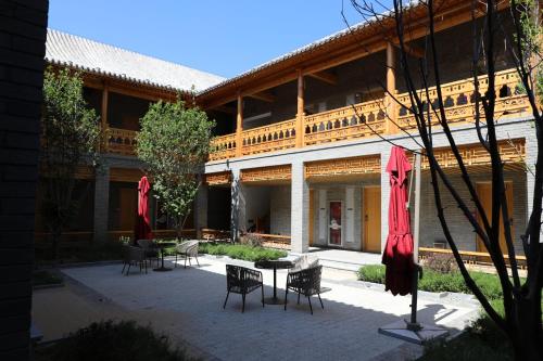 a courtyard with chairs and tables and umbrellas in front of a building at Jinshanling Great Wall Hotel in Chengde