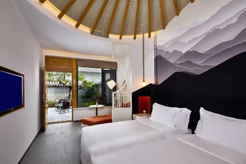 a hotel room with two beds and a tv at Jinshanling Great Wall Hotel in Chengde