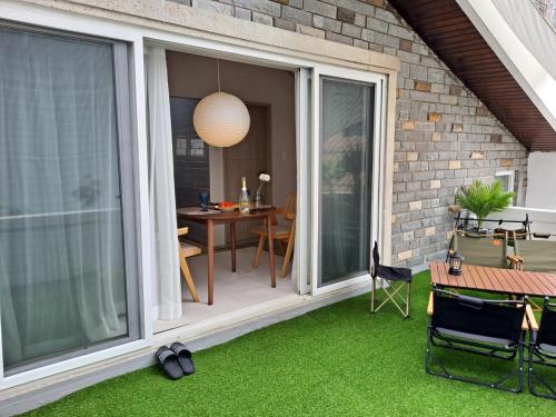 a sliding glass door on a patio with a table and chairs at Soban Stay in Busan