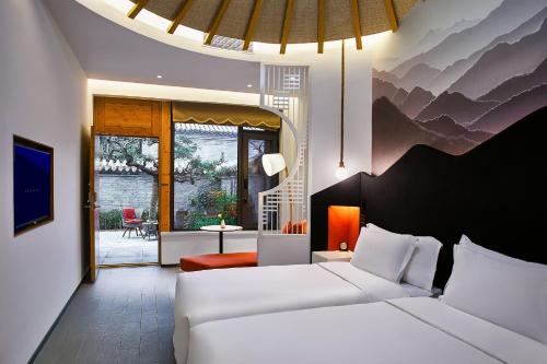 a bedroom with two beds and a living room at Jinshanling Great Wall Hotel in Chengde