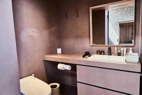 a bathroom with a sink and a toilet at Snow Peak YAKEI SUITE ABURAYAMA FUKUOKA in Fukuoka