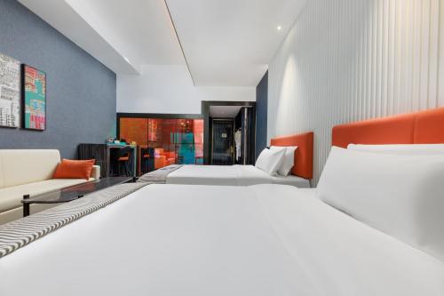 a hotel room with two beds and a couch at CityNote Hotel - Guangzhou Donghu Metro Station Pearl River Night Tour Dashatou Pier Shop in Guangzhou