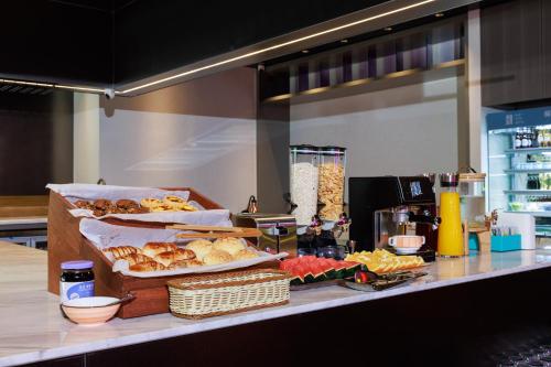 a buffet with bread and other food on a counter at CityNote Hotel - Guangzhou Donghu Metro Station Pearl River Night Tour Dashatou Pier Shop in Guangzhou