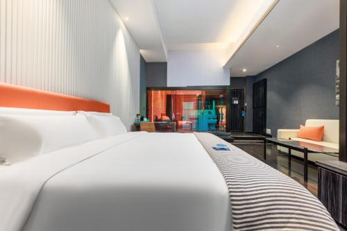 a bedroom with a white bed and a living room at CityNote Hotel - Guangzhou Donghu Metro Station Pearl River Night Tour Dashatou Pier Shop in Guangzhou