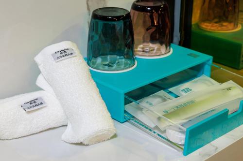 a blue nightstand with a roll of toilet paper and towels at CityNote Hotel - Guangzhou Donghu Metro Station Pearl River Night Tour Dashatou Pier Shop in Guangzhou