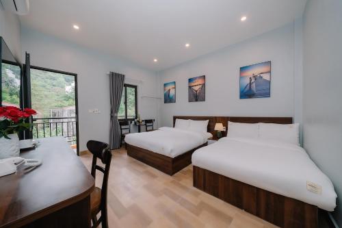 カットバ島にあるNapoli Hostelのベッド2台、デスク、デスクが備わる客室です。