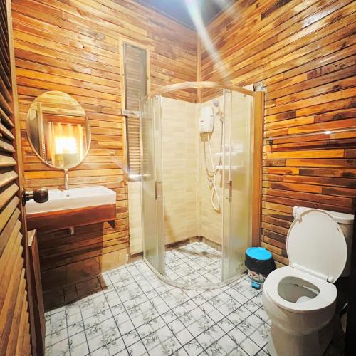 a wooden bathroom with a shower and a toilet at Maingern Maithong Resort in Sara Buri