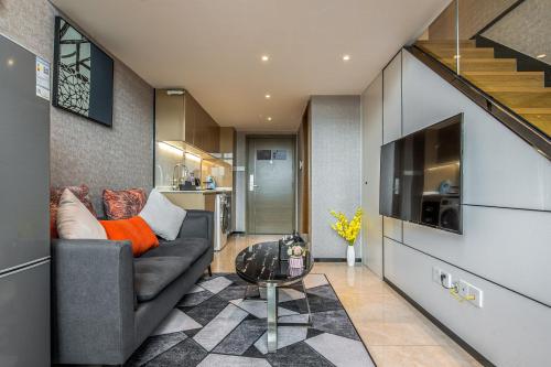 a living room with a couch and a television at Zun Xiang Executive Apartment - Shenzhen Futian Exhibition Center in Shenzhen
