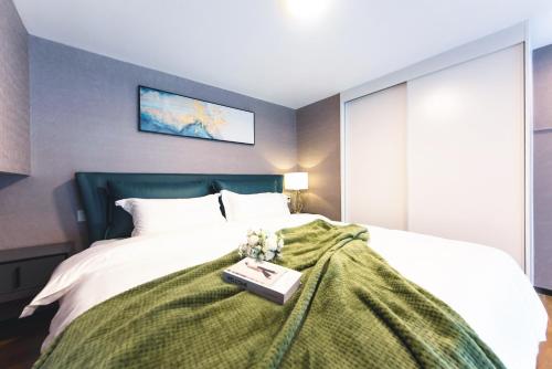 a bedroom with a bed with a book on it at Zun Xiang Executive Apartment - Shenzhen Futian Exhibition Center in Shenzhen