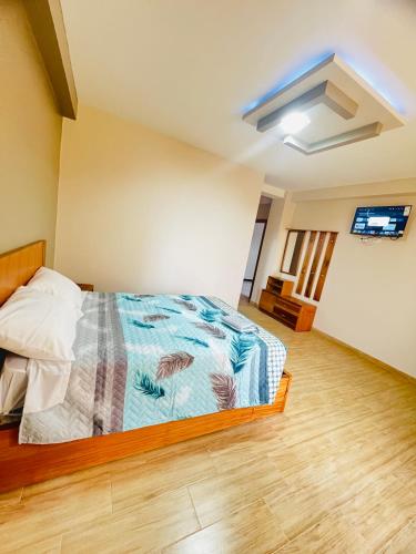 a bedroom with a bed and a flat screen tv at Hostal Paraíso de Los Andes in Riobamba