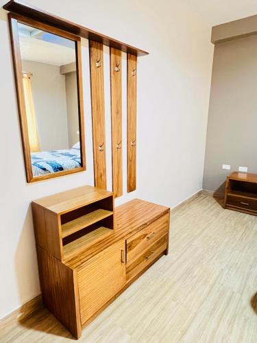 a dressing room with a mirror and a wooden dresser at Hostal Paraíso de Los Andes in Riobamba
