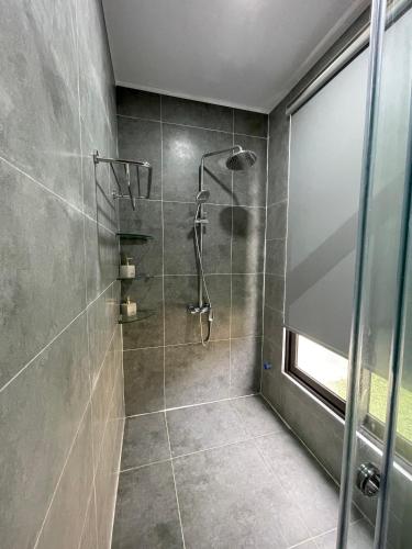 a bathroom with a shower with a glass door at AKIRA VILLA _ Venuestay in Ba Vì