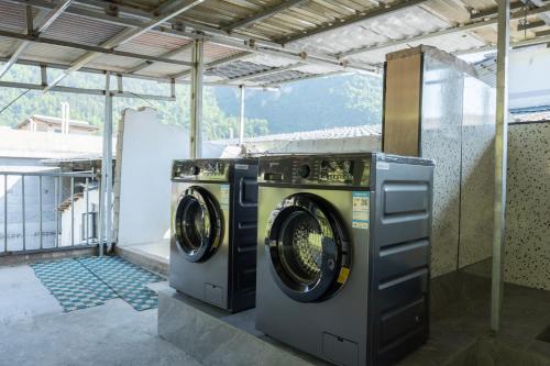 two washing machines sitting inside of a building at 铂曼智慧酒店-张家界国家森林公园门票站店 in Zhangjiajie