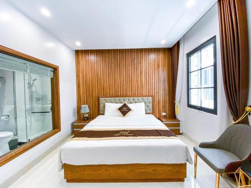 um quarto com uma cama, uma cadeira e uma janela em An Hotel Ha Long em Ha Long