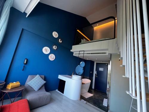 ein Wohnzimmer mit einer blauen Wand mit Platten darauf in der Unterkunft Hayata Hotel in Altstadt von Hengchun