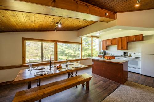 uma cozinha com uma mesa de madeira e um banco em 4 Bedroom Blue Mountain Chalet, Private Beach Access, BBQ, Petfriendly em Blue Mountains