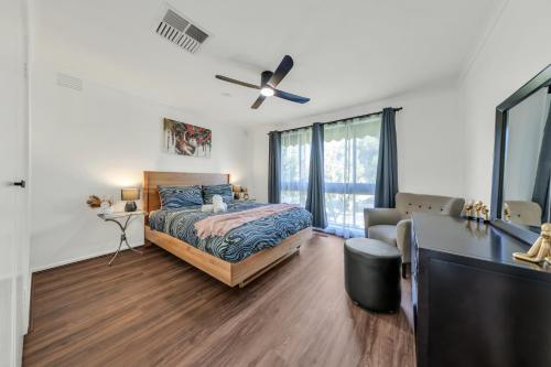 1 dormitorio con 1 cama y ventilador de techo en House near Melbourne Airport en Melbourne