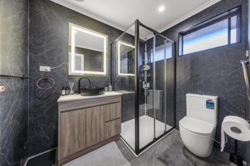 ein Bad mit einem WC, einem Waschbecken und einer Dusche in der Unterkunft House near Melbourne Airport in Melbourne