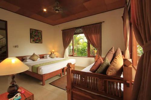 a bedroom with a bed and a window at Villa Agung Khalia Ubud in Ubud
