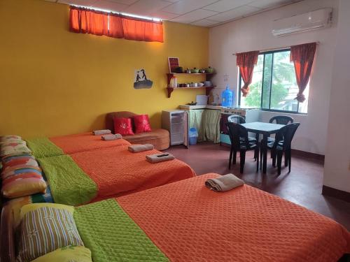 a room with two beds and a table with chairs at Mí oficina in Puerto Ayora
