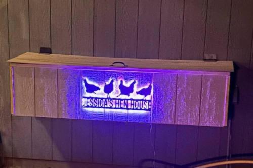 a purple sign with two birds on a wall at Matchbox desert oasis hot tub, pet friendly! in Las Cruces