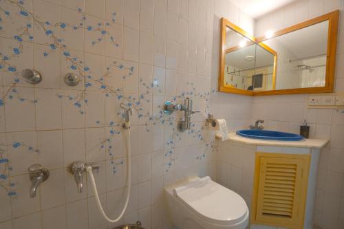 a bathroom with a shower and a toilet and a mirror at House of Stories - Indiranagar, Bangalore in Bengaluru
