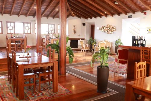 Vista del Angel Hotel Boutique في كيتو: غرفة طعام مع طاولات وكراسي خشبية