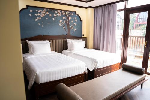 Legacy Hill Resort & Villas في Hòa Bình: غرفة فندقية بسريرين ونافذة