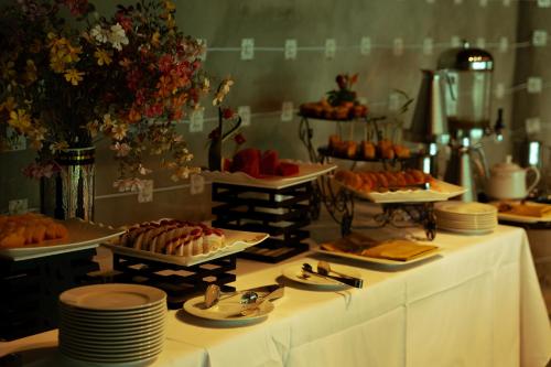 a buffet with plates and desserts on a table at Legacy Hill Resort & Villas in Hòa Bình