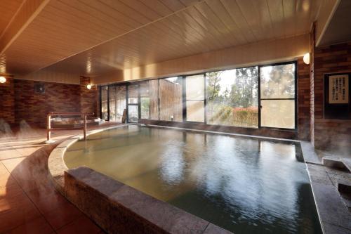 a swimming pool in a building with a large window at Yamagataya in Kitakata